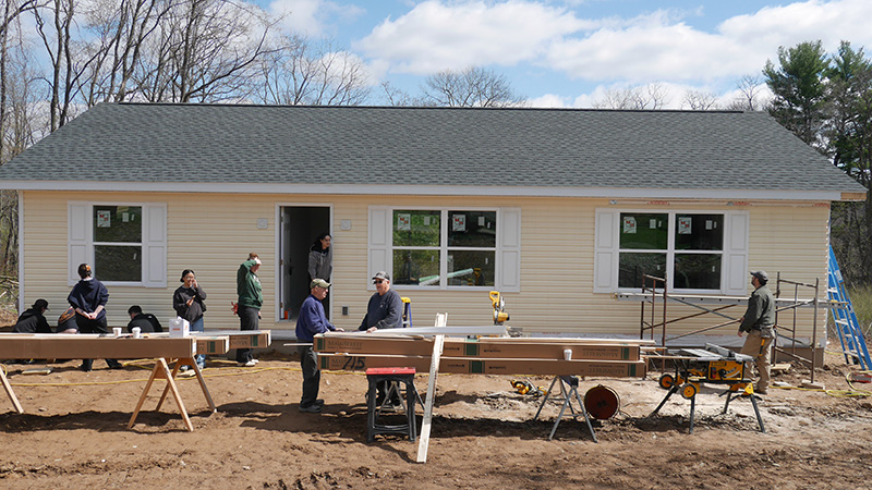 a yellow house with people working